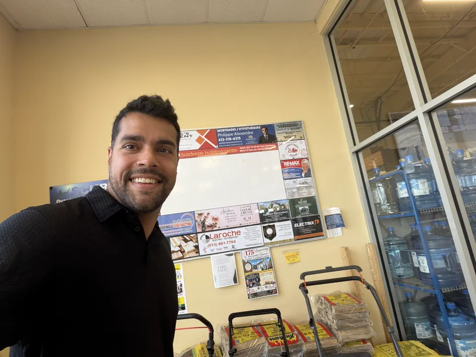 Mortgage agent Philippe Alexandre beside the community advertising board at Home Hardware in Alexandria, Ontario